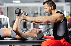 Fitness instructor assisting young woman