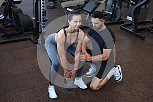 Fitness instructor exercising with his client at the gym