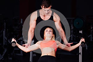 Fitness instructor exercising with his client at the gym.