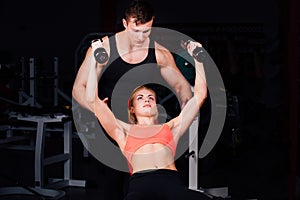 Fitness instructor exercising with his client at the gym.