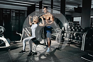 Fitness instructor exercising with his client at the gym.