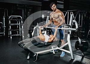 Fitness instructor exercising with his client at the gym.