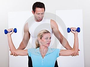 Fitness instructor helping a woman workout