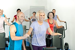 Fitness instructor leading gym people exercise