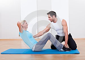 Fitness instructor teaching sit ups