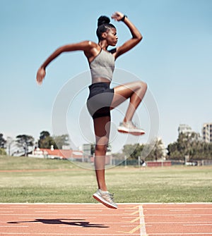 Fitness, jump or black woman runner on a race track in training, cardio workout or sports exercise in summer. Jumping