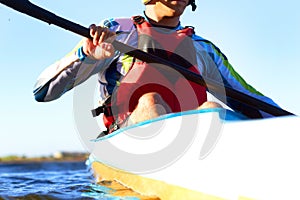 Fitness, kayak and a man rowing in the water of a river alone outdoor in nature during summer adventure. Sports