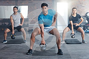 Fitness, kettlebell weight and people doing an exercise for strength, wellness or health together in a gym. Sports