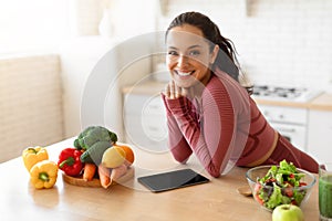 Fitness lady websurfing healthy recipes on digital tablet in kitchen