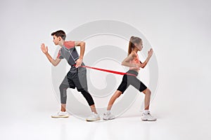 Fitness leaders. Full-length shot of teenage boy and girl engaged in sport, looking focused while exercising using