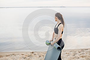 Fitness and lifestyle concept - woman doing sports outdoors on a beach