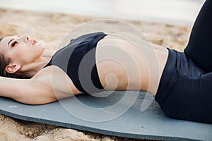 Fitness and lifestyle concept - woman doing sports outdoors on a beach