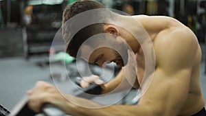 Fitness man athlete training hand muscles, enjoying difficult endurance practice in gym