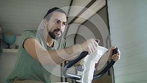 Fitness man on bicycle doing spinning at gym.