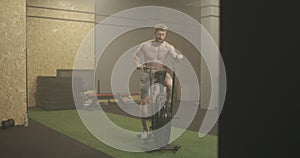 Fitness man on bicycle doing spinning at gym. Fit young male working out on gym bike. Male exercising on bicycle in