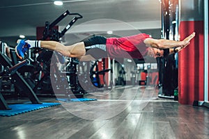 Fitness man doing extreme push ups in gym. Selective focus