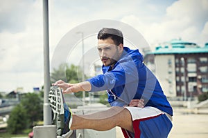 Fitness man doing stretches outdoors