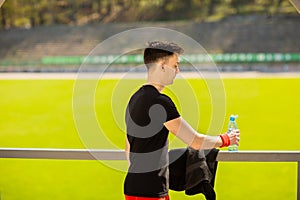 Fitness man drinking water from bottle. Thirsty athlete having cold refreshment drink after intense exercise