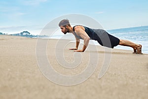Fitness Man Exercising, Doing Push Ups Exercise On Beach. Sports