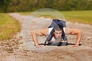 Fitness man exercising push ups, outdoor. Muscular male cross-training outside