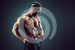 Fitness man exercising with stretching band. Muscular sports man exercising with elastic rubber band. Guy working out