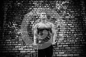 Fitness man exercising with stretching band in outdoor gym.