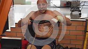 Fitness man furiously rowing on simulator while training in gym