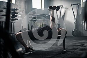 Fitness Man Has Training at Gym With Dumbbells .