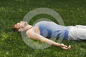 Fitness man have rest lying on green grass