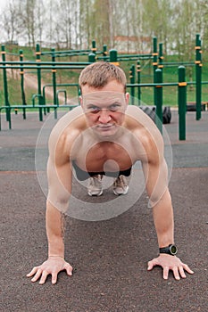 Fitness man with perfect body doing abdominal exercises in the Gym