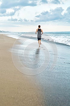 Fitness Man Running On Beach. Runner Jogging During Outdoor Workout