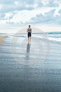 Fitness Man Running On Beach. Runner Jogging During Outdoor Workout