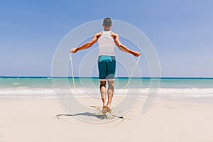 Fitness man skipping on the beach