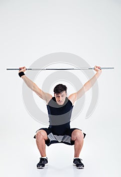 Fitness man squatting with barbell