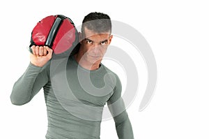 Fitness man in tight shirt posing with sack of sand on his shoulder.