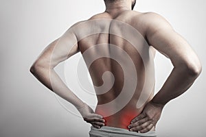 Fitness man touching his lower back pain zone