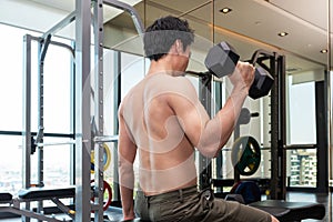Fitness man are training or exercising by lifting dumbbells. in Fitness room at sport gym