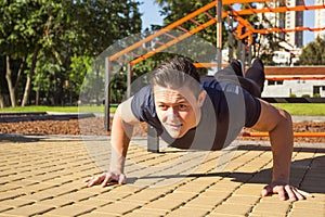 Fitness man training push up in the park