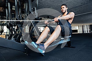 Fitness man using rowing machine at gym