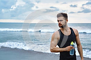 Fitness Man With Water Bottle Resting After Workout At Beach
