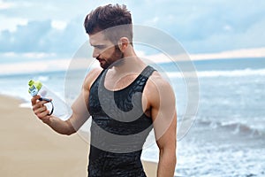 Fitness Man With Water Bottle Resting After Workout At Beach
