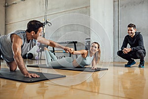 Fitness man and woman buddies do fist bump in gym after the workout.