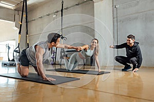 Fitness man and woman buddies do fist bump in gym after the workout.