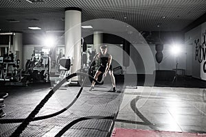 Fitness man working out with battle ropes at gym. Battle ropes fitness man at gym workout exercise fitted body. Fitness man traini