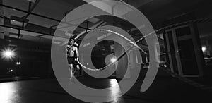 Fitness man working out with battle ropes at a gym