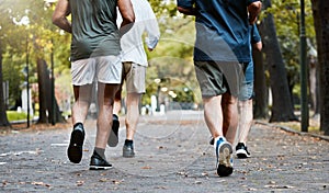 Fitness, men and running club in park, cropped legs in nature for exercise on garden path together. Motivation, workout