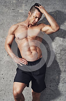 Fitness model portrait, muscular build man relaxing.