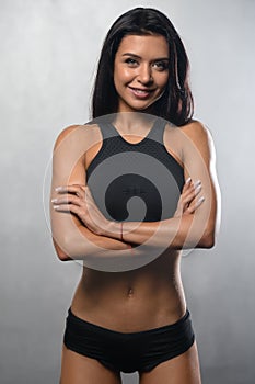 Fitness model posing in studio on a white grey background