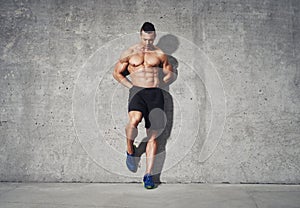 Fitness model standing against grey background