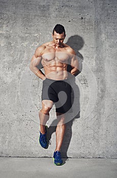 Fitness model standing against grey background, close up
